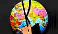 una mano che tiene la bacchetta di un direttore d'orchestra sovrapposta al globo che mostra i paesi