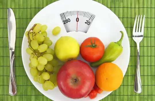 Frugt og grøntsager på en tallerken, der ligner en badeværelsesvægt.
