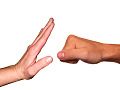 a hand raised to stop a fist coming towards it