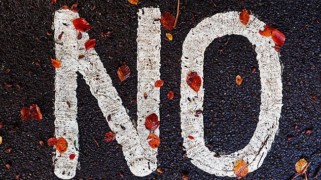 ordet "NEJ" skrivet på trottoaren