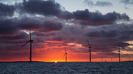 Le soleil se lève derrière un parc éolien offshore. Image: Aaron via Flickr