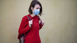 girl wearing a Covid mask outside carrying a backpack