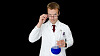 практикующий врач держит стакан с голубой жидкостью