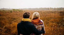 couple regardant un champ herbeux nu