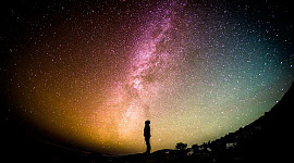 Orang, berdiri dan melihat ke arah bintang-bintang dan Bima Sakti.