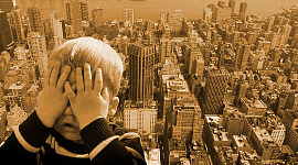 boy covering up his face as if afraid of the tall city landscape behind him