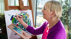 en kvinna som håller en palett och arbetar på en målning