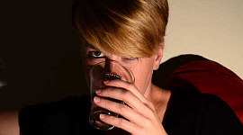 жінка, приймаючи напій зі склянки