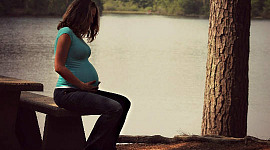 المرأة الحامل جالسة ويدها على بطنها