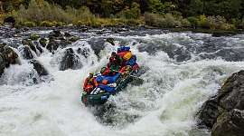 group of people riding the rapids in a raft
