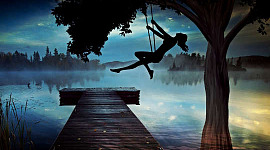 黃昏時分，一個女孩在鞦韆上高高的剪影，看著霧濛濛的湖水