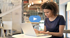 Mujer molesta sentada frente a su computadora portátil abierta