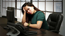 mujer sentada en su escritorio con cara de preocupación