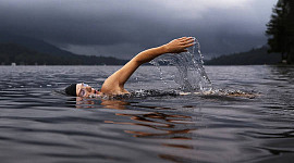 một vận động viên bơi lội trong vùng nước rộng lớn