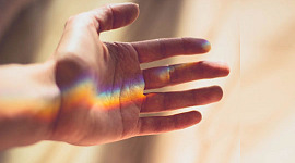 um arco-íris na palma de uma mão aberta