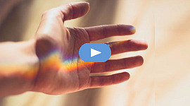 en regnbue i håndfladen på en åben hånd