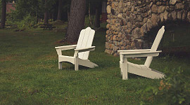 hai chiếc ghế trống trên bãi cỏ từ một bức tường đá