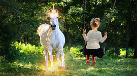 دختر جوان روی تاب و به یک اسب شاخدار نگاه می کند