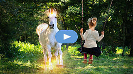 fată tânără aflată într-un leagăn privind un unicorn