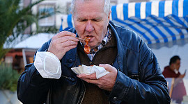 رجل يأكل الوجبات السريعة