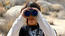 young boy looking through binoculars