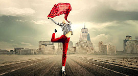 אישה רוקדת באמצע כביש מהיר ריק עם קו רקיע של העיר ברקע