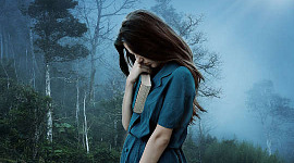 Kobieta, smutna, trzyma grubą zamkniętą książkę i zwiesza głowę