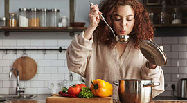 امرأة تذوق الطعام أثناء الطهي