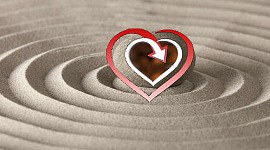 corazón superpuesto en un círculo de arena perfecto con sus olas expandiéndose hasta el infinito