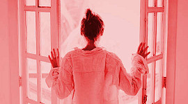 kvinna tittar ut öppna altandörrar