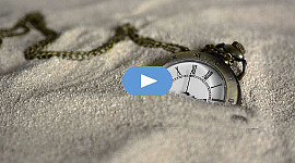 ένα ρολόι τσέπης μισοχαμμένο στην άμμο