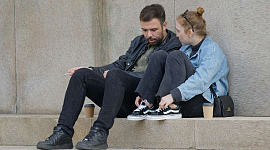 couple ayant une conversation assis dehors sur les marches