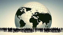 Viele Menschen umgeben einen schwarz-weißen Globus des Planeten Erde