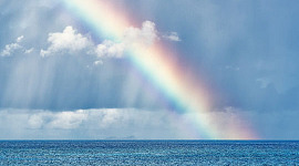 um arco-íris brilhando na água