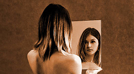 زنی که در آینه به خودش نگاه می کند