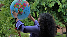 wanita memegang glob planet ini