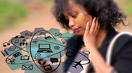 एक युवा महिला अपने फ़ोन को इसके अनेक ऐप्स और संभावनाओं के साथ देख रही है