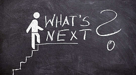 een stokfiguur die de trap naar succes beklimt en de woorden "What's Next?"