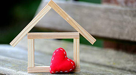 um coração com costura e uma casa em construção
