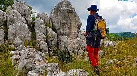 a man with a backpack standing in front of rocks and boulders