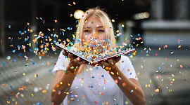 vrouw blaast confetti van een open boek