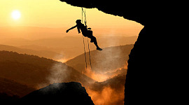 een vrouw die aan het bergbeklimmen is, hangend in de lucht