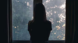 صورة ظلية لامرأة تقف أمام نافذة