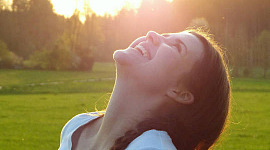 ung kvinne med ansiktet vendt opp mot solen