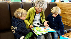 seorang nenek membaca untuk kedua cucunya
