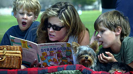عورت دو چھوٹے بچوں کو پڑھ رہی ہے۔