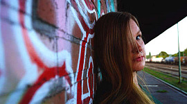 ung kvinne eller jente som står mot en graffiti-vegg