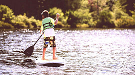 een jonge jongen op een paddleboard