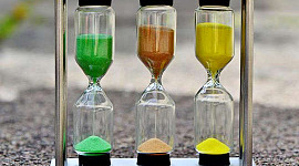 three hour glasses: one with green sand, the other red, and the other yellow