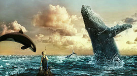 balene di mare che saltano in alto con un bambino che guarda